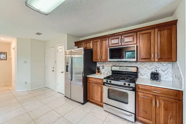 a kitchen with stainless steel appliances a stove microwave and a refrigerator