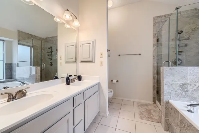 a bathroom with a sink vanity toilet and shower