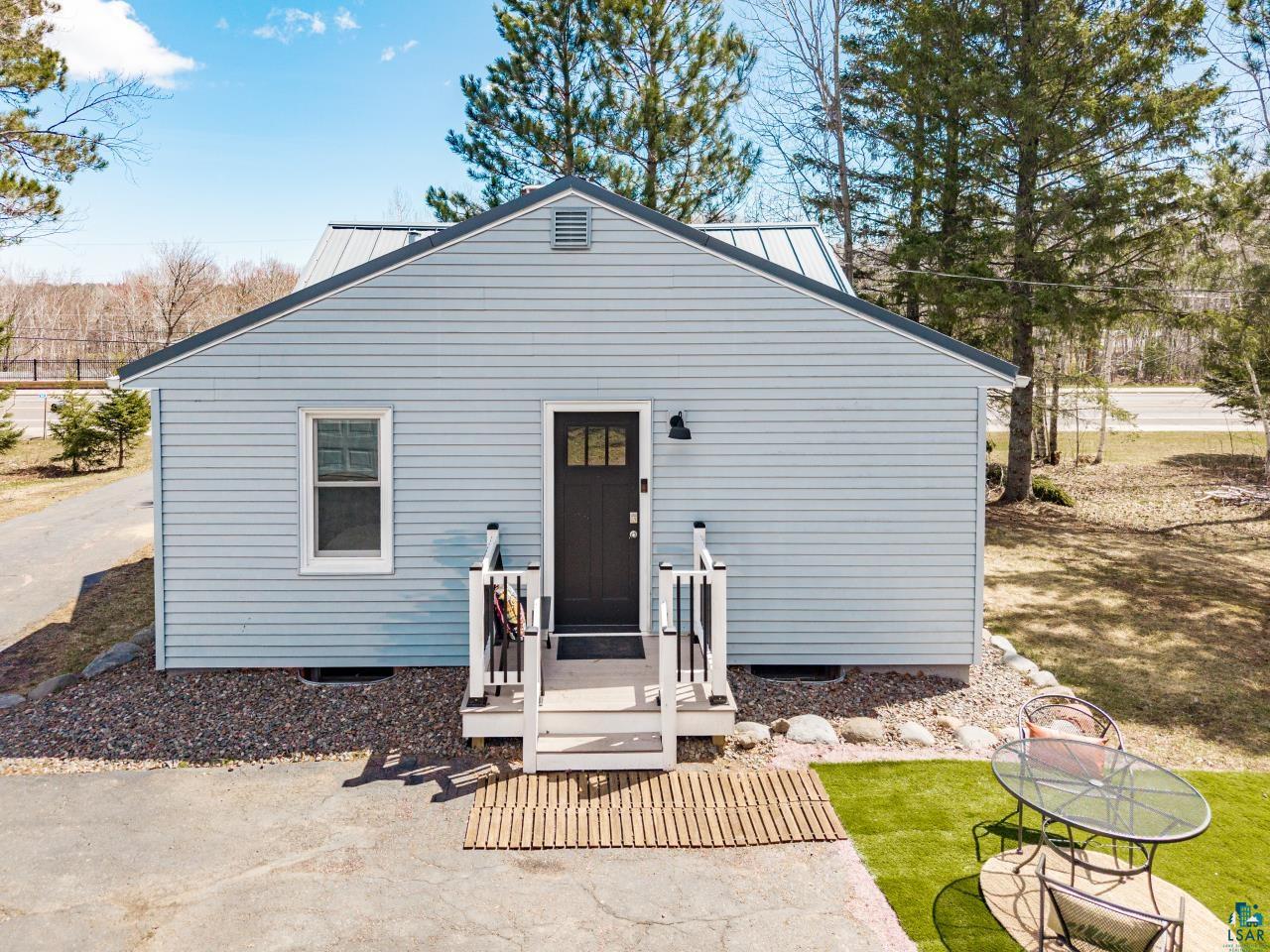 3645 Haines Road Hermantown, MN 55811 - Photo 5 of 35 Light blue horizontal siding facade featuring a dark entry door with upper window panes
