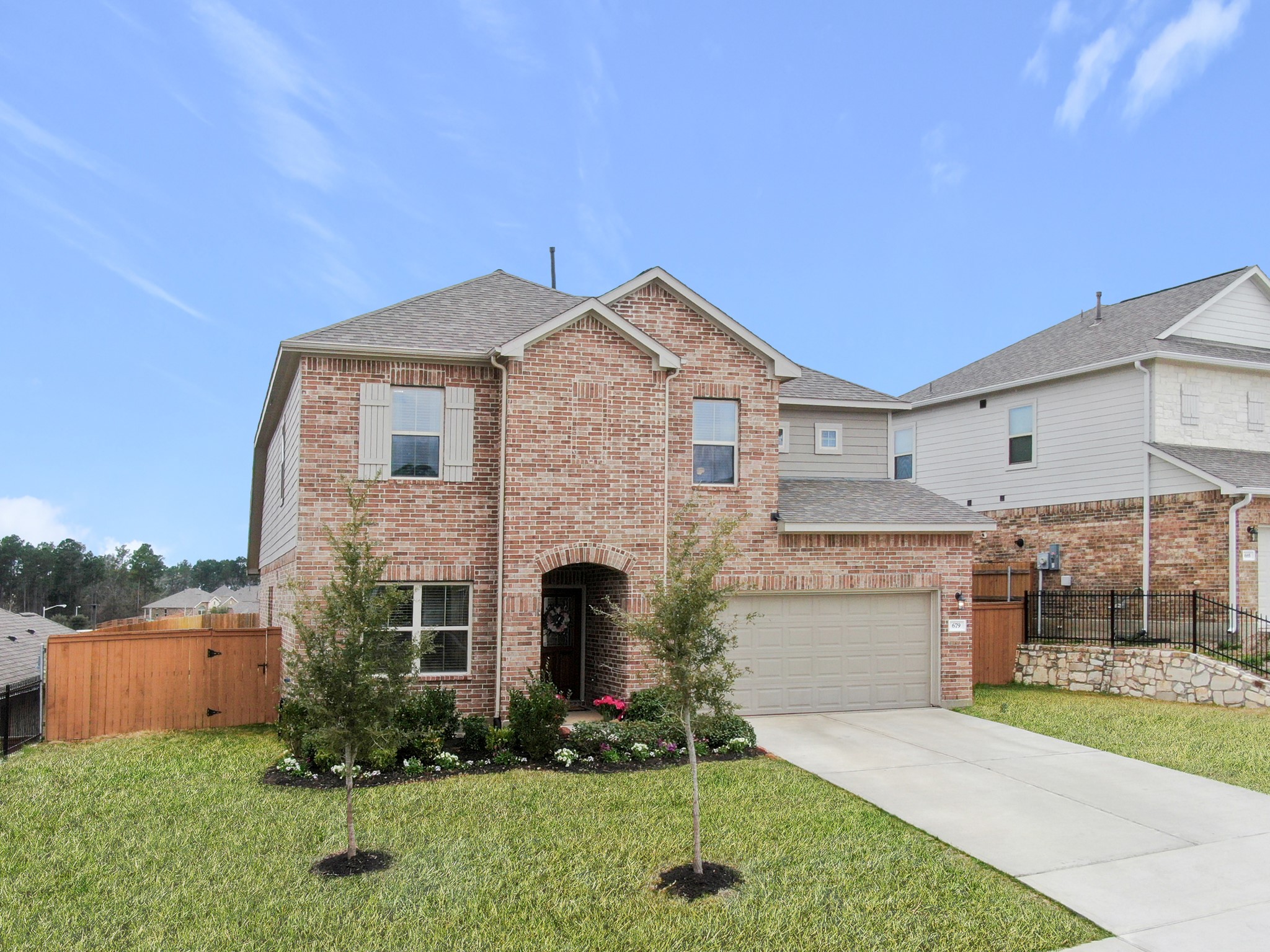 679 Red Elm Lane Conroe, TX 77304 - Photo 3 of 45 a front view of a house with a yard and garage