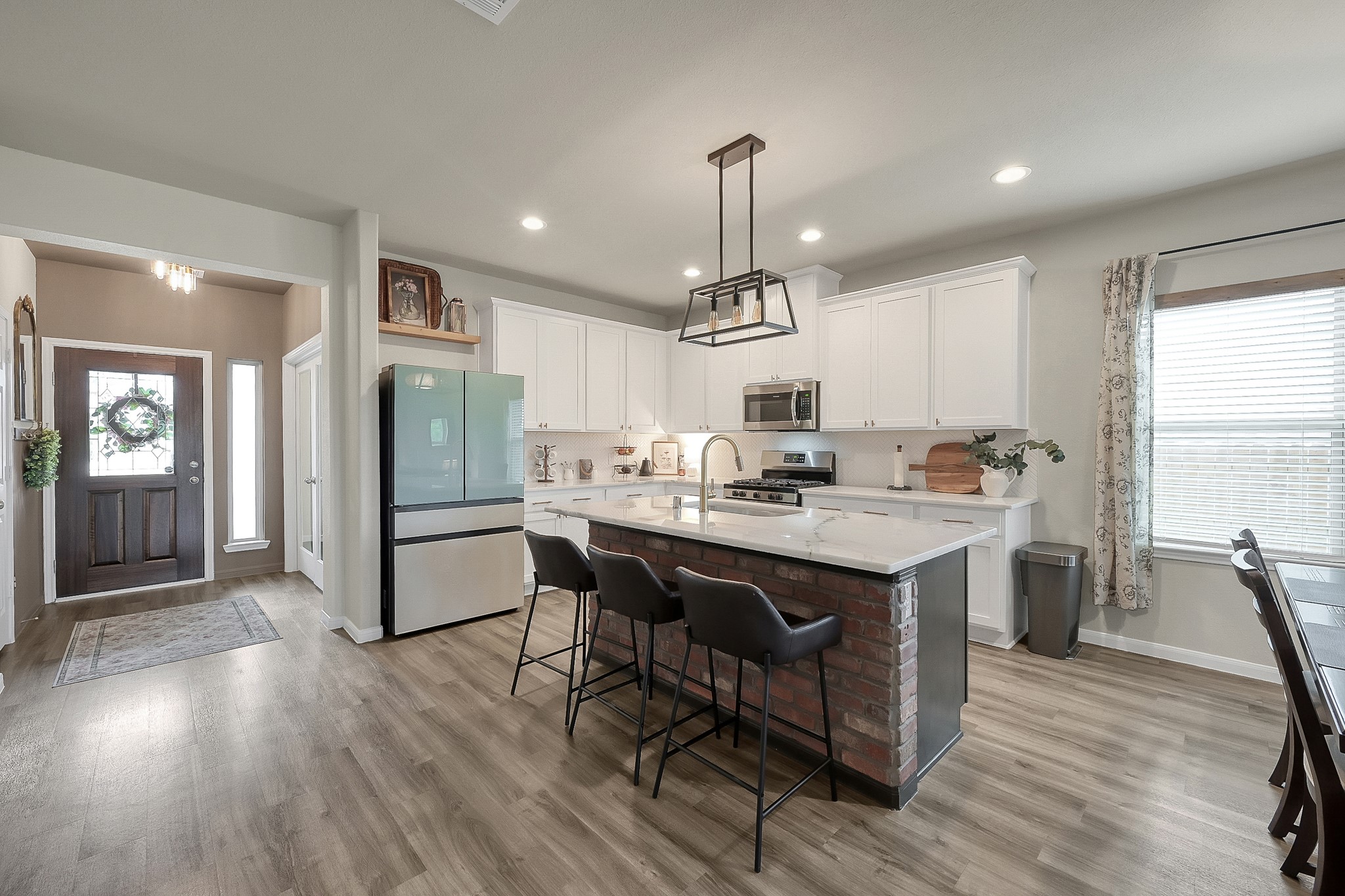 679 Red Elm Lane Conroe, TX 77304 - Photo 10 of 45 a kitchen with stainless steel appliances a dining table chairs stove and refrigerator