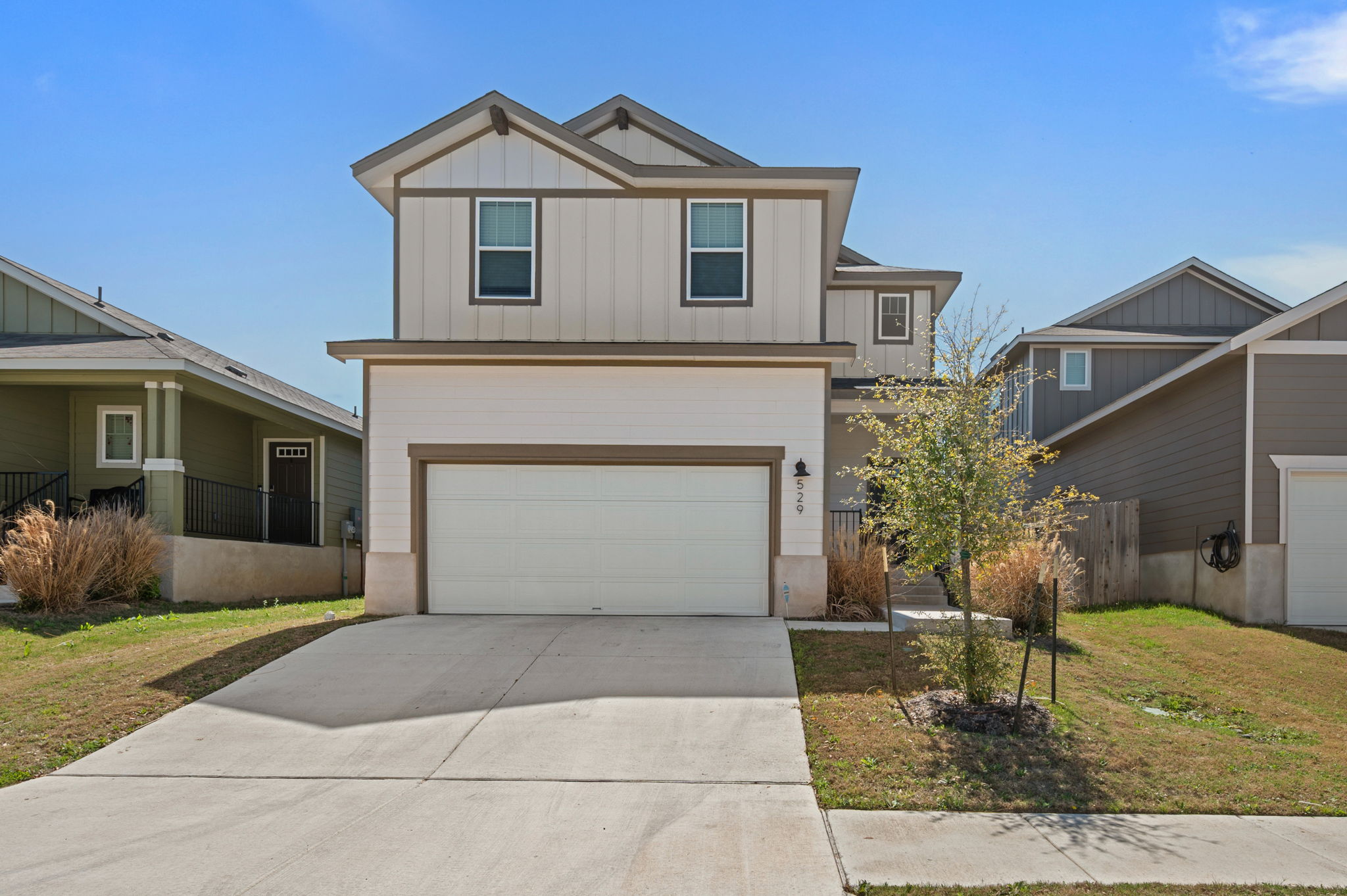 529 View Drive Georgetown, TX 78628 - Photo 1 of 20 View of front of property featuring concrete driveway, a front yard, board and batten siding, and an attached garage