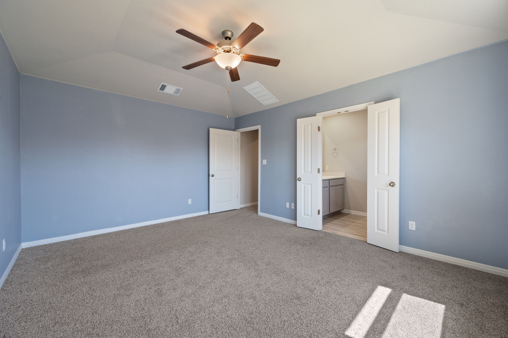 529 View Drive Georgetown, TX 78628 - Photo 14 of 20 Unfurnished bedroom featuring lofted ceiling, light carpet, a ceiling fan, and ensuite bathroom