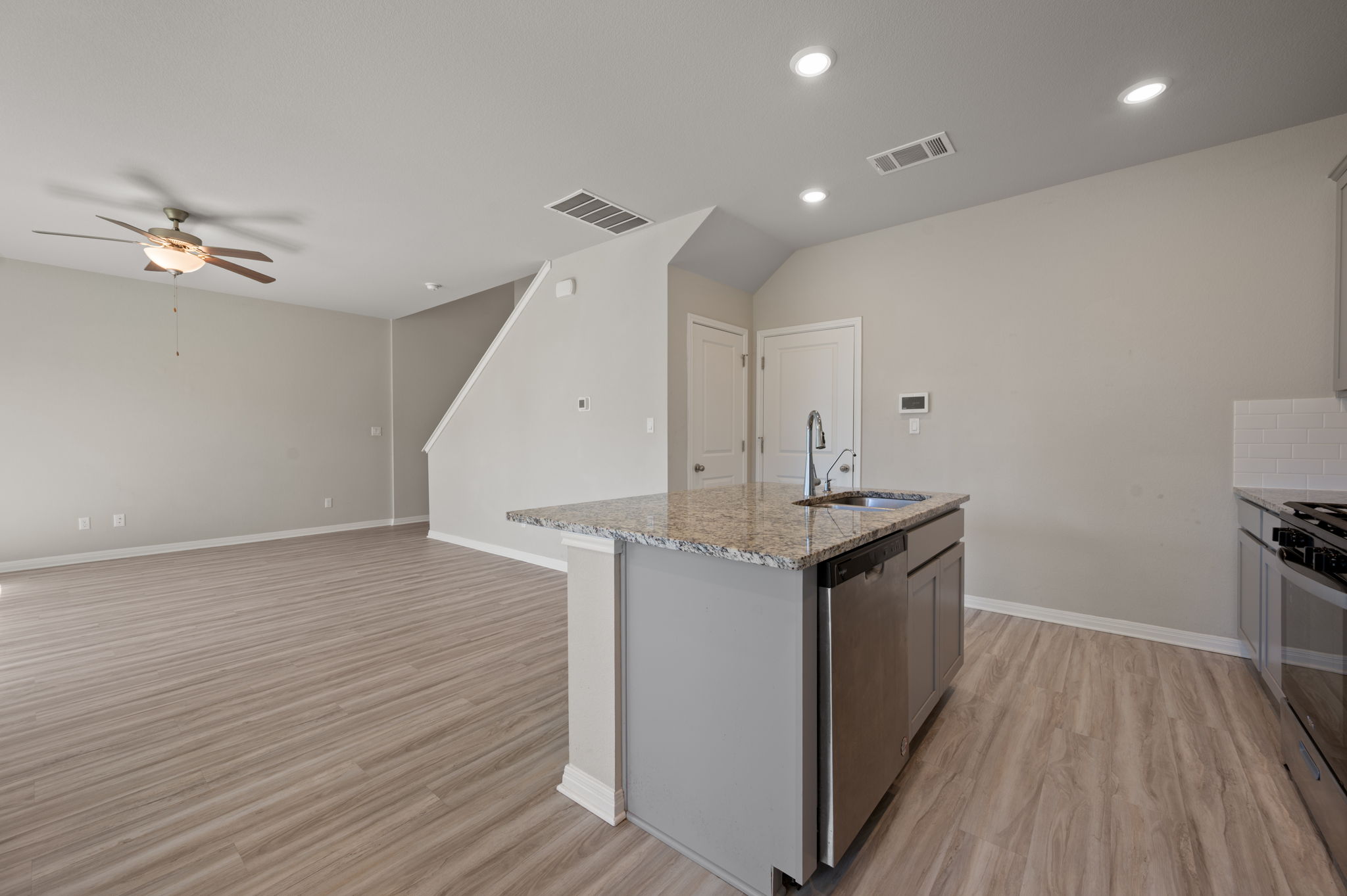 529 View Drive Georgetown, TX 78628 - Photo 9 of 20 Kitchen featuring light stone counters, an island with sink, stainless steel appliances, light wood-style floors, and ceiling fan