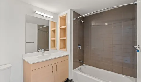 a bathroom with a shower sink vanity and mirror