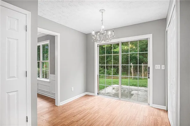 a view of a room with wooden floor a ceiling fan and a window