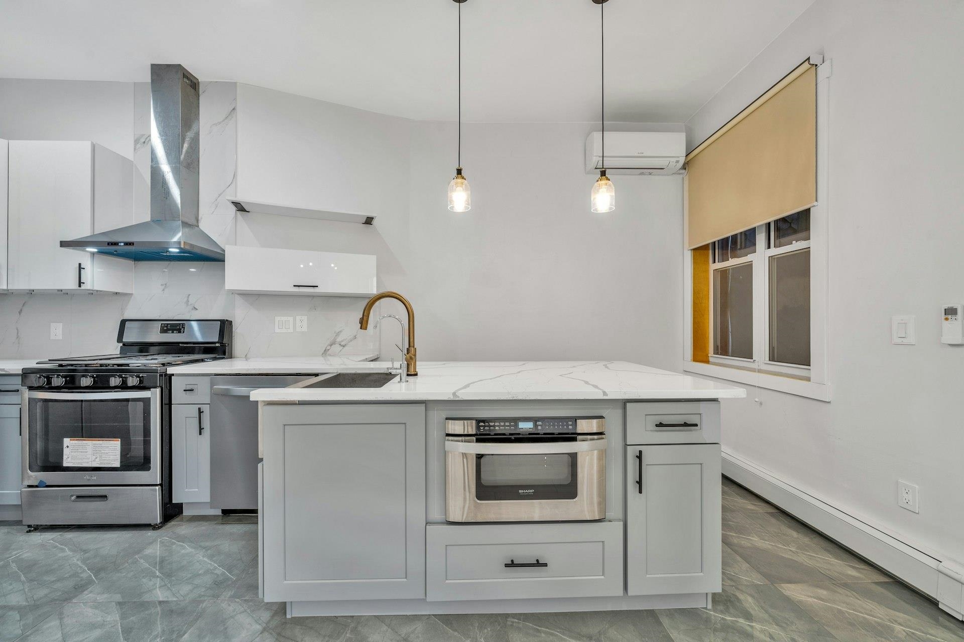 202 48th Street, Unit 3 Union City, NJ 07087 - Photo 4 of 17 a kitchen with stainless steel appliances granite countertop a stove a sink and a microwave