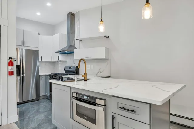 a kitchen with stainless steel appliances a stove a sink and a refrigerator