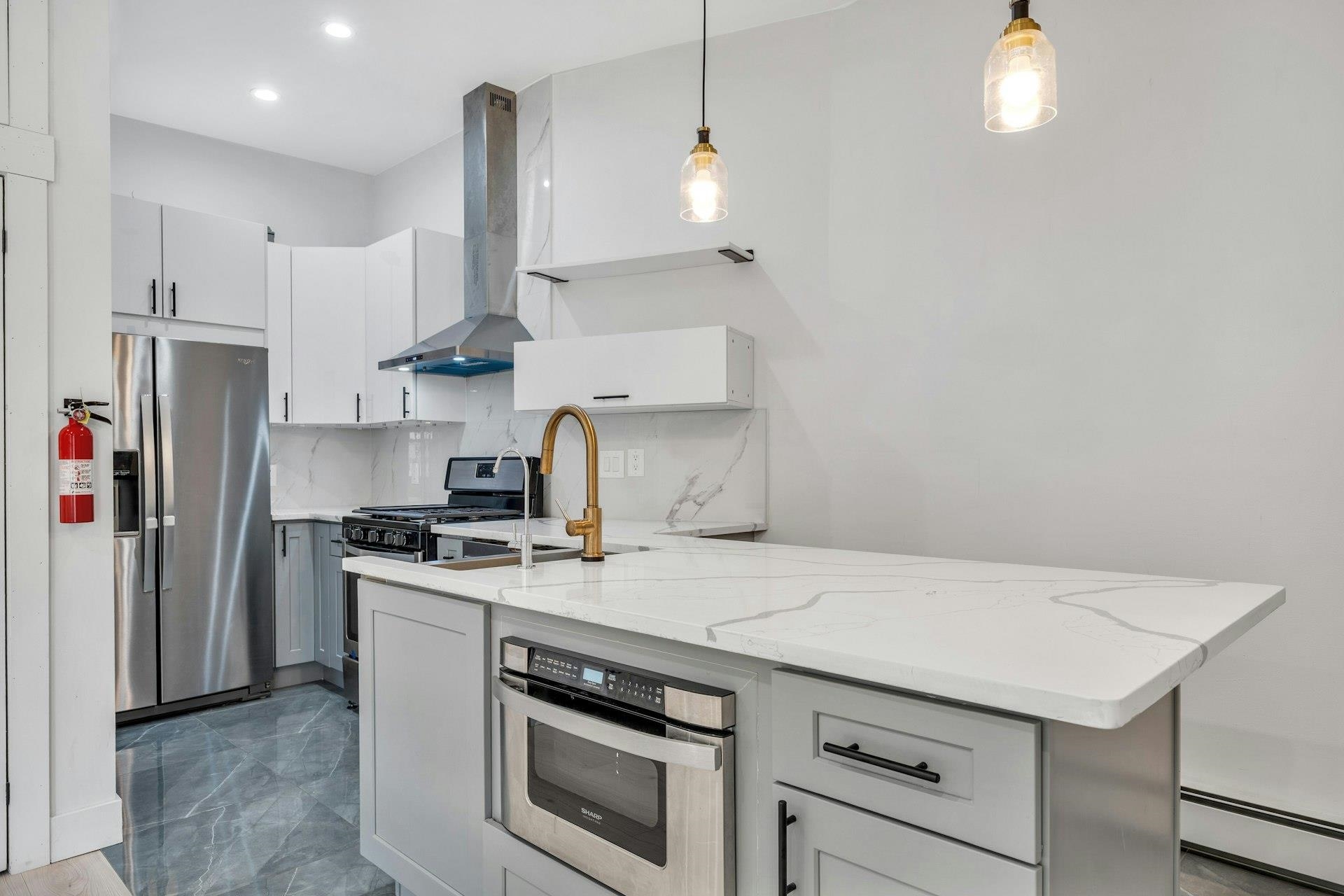 202 48th Street, Unit 3 Union City, NJ 07087 - Photo 5 of 17 a kitchen with stainless steel appliances a stove a sink and a refrigerator
