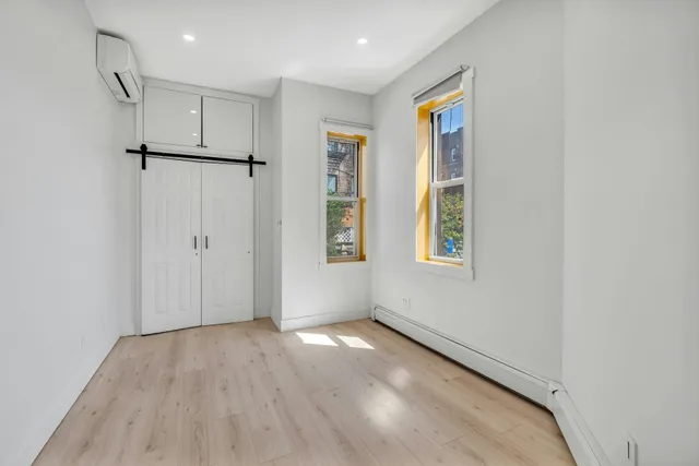 a view of empty room with wooden floor and window