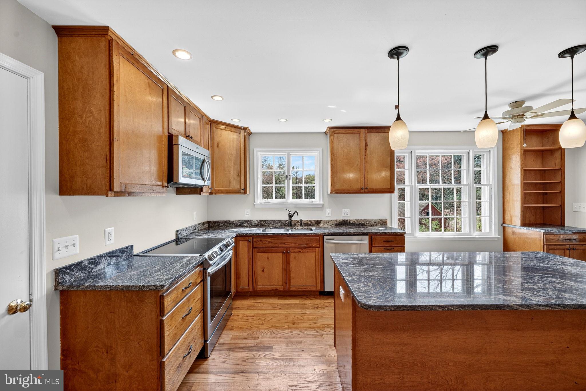 19635 Eagle Mill Road Parkton, MD 21120 - Photo 22 of 86 a kitchen with granite countertop kitchen island stainless steel appliances a sink stove and cabinets