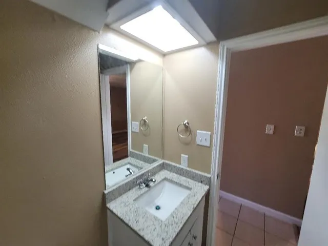 a bathroom with a sink vanity and a mirror