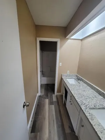 a bathroom with a granite countertop sink and washing machine