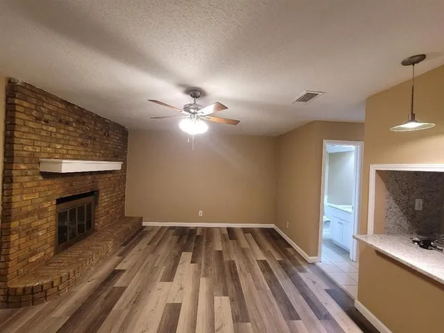 a view of a livingroom with wooden floor and a fireplace