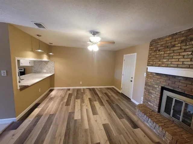 a view of wooden floor wooden cabinets and a kitchen space with a sink