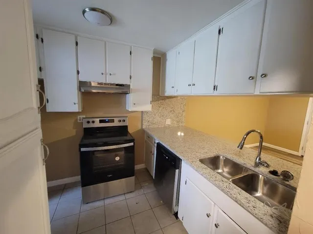 a kitchen with sink a stove and cabinets