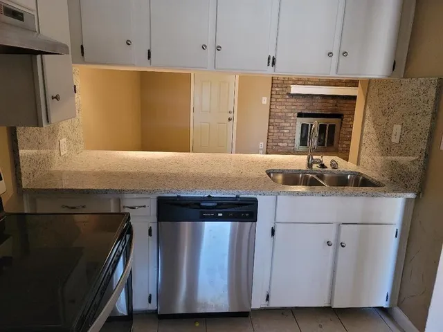 a kitchen with granite countertop cabinets stainless steel appliances and a counter space