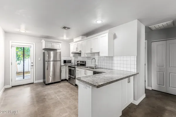 a kitchen with stainless steel appliances granite countertop a refrigerator sink and stove
