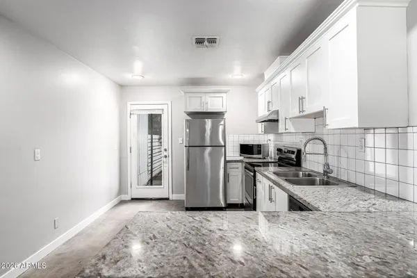 a view of kitchen with refrigerator and wooden floor