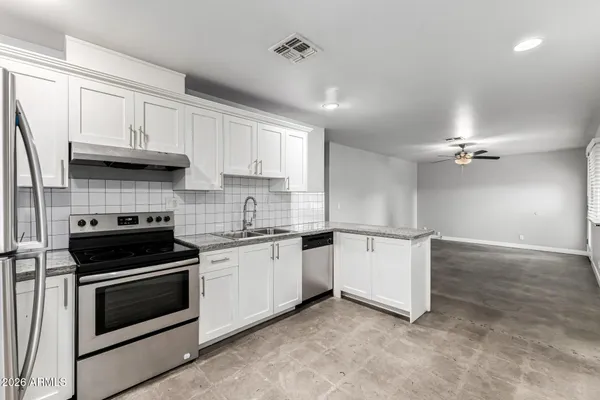 a view of a kitchen with a sink and dishwasher with wooden floor