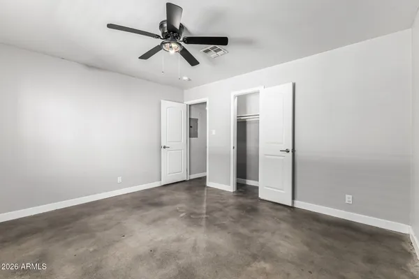 an empty room with a window and a fan