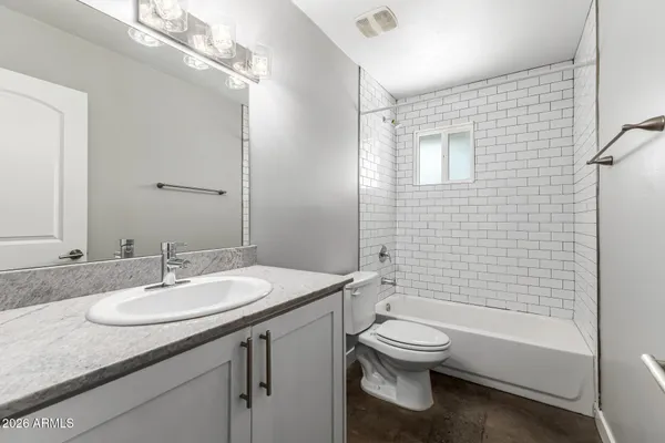 a spacious bathroom with a granite countertop sink toilet and a mirror