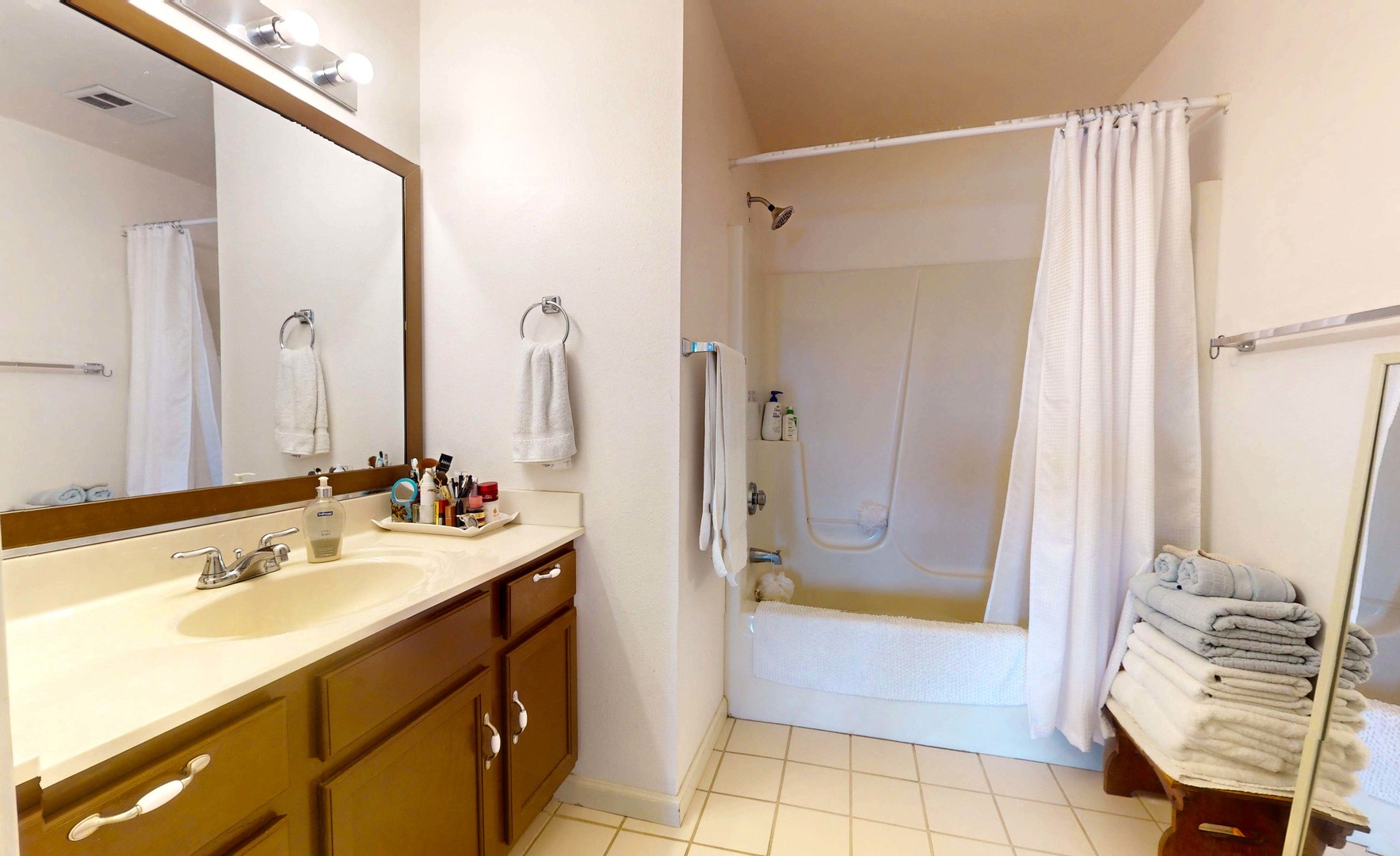 2408 Windward Boulevard, Unit 106 Champaign, IL 61821 - Photo 8 of 17 a bathroom with a double vanity sink a mirror and a bathtub