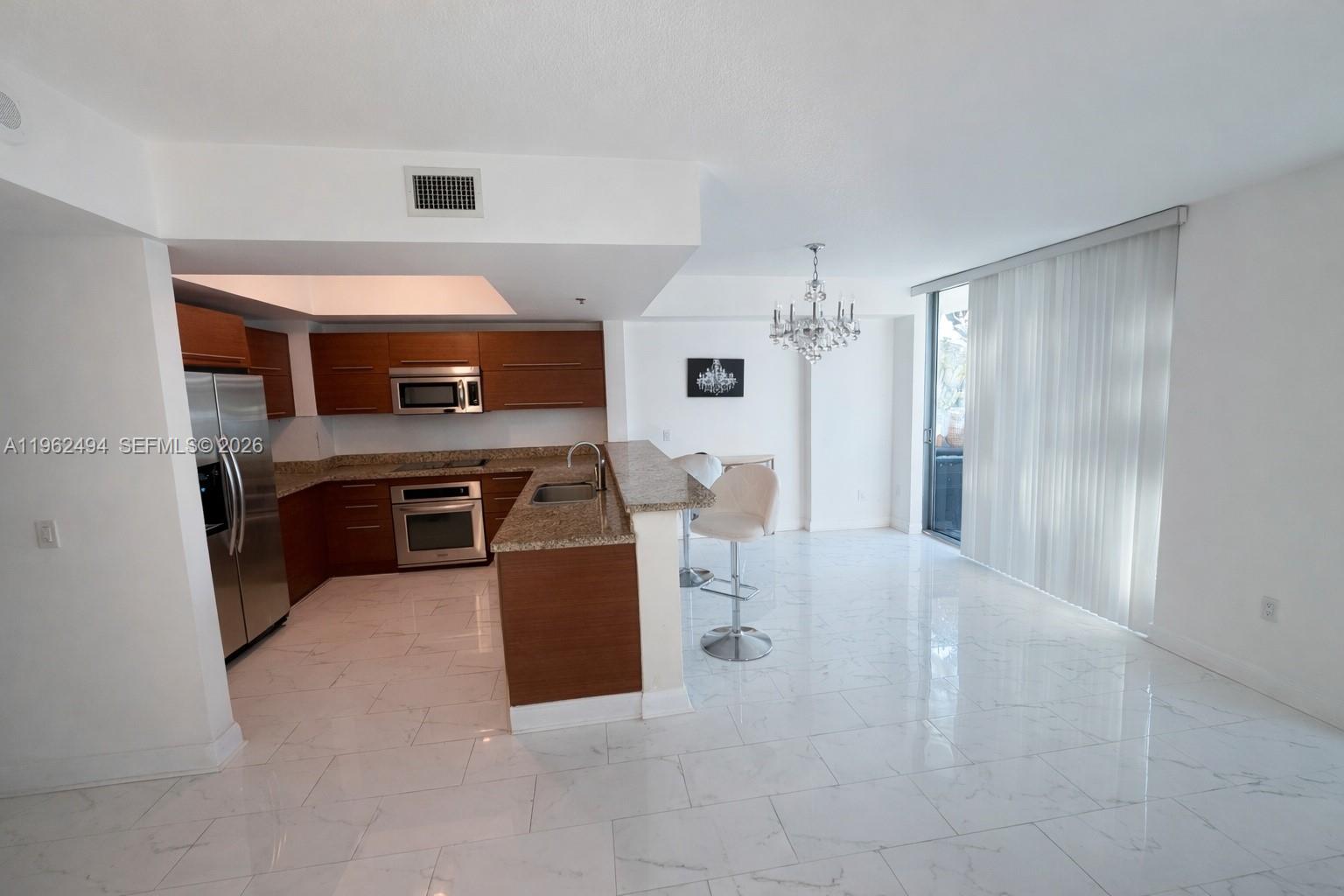 2641 North Flamingo Road, Unit TH5N Sunrise, FL 33323 - Photo 10 of 12 a kitchen with cabinets and stainless steel appliances