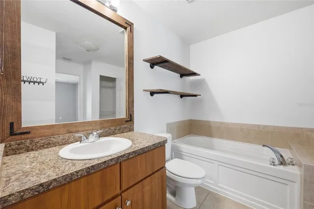 a bathroom with a granite countertop sink mirror vanity and toilet