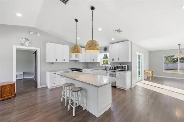 a kitchen with a stove a refrigerator a sink dishwasher with a dining table and chairs