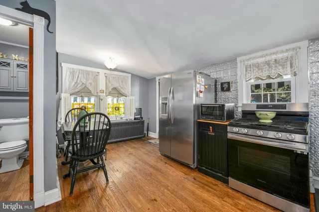 a kitchen with kitchen island a dining table chairs and a refrigerator