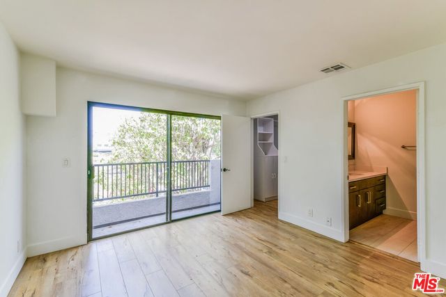 a view of a room with wooden floor and cabinet
