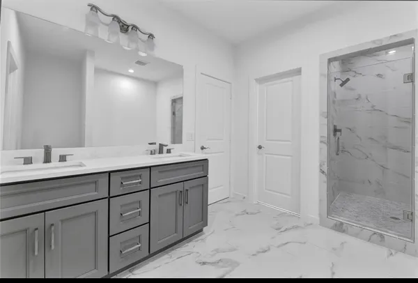 a bathroom with double sink and a mirror