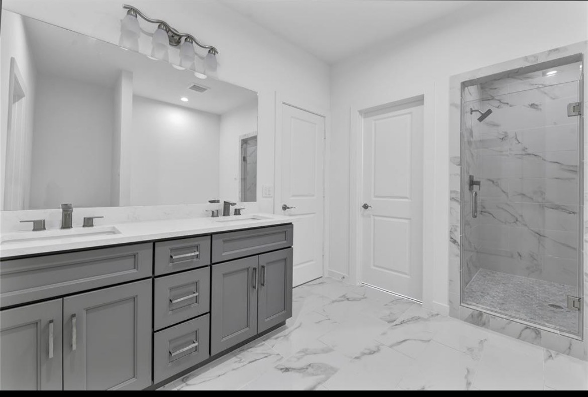 207 Edgewood Street, Unit B Houston, TX 77011 - Photo 17 of 23 a bathroom with double sink and a mirror