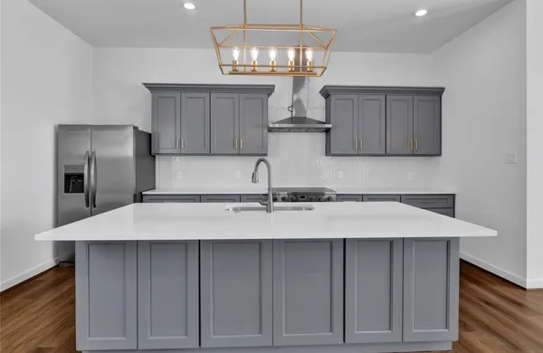 a kitchen with a sink refrigerator and cabinets