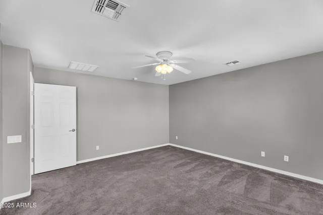 a view of a big room with chandelier fan and windows