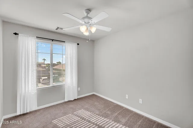 an empty room with chandelier fan