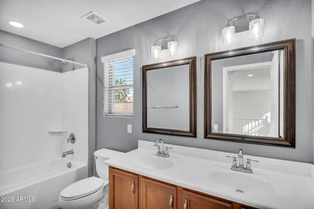 a bathroom with a toilet a sink a tub and a mirror