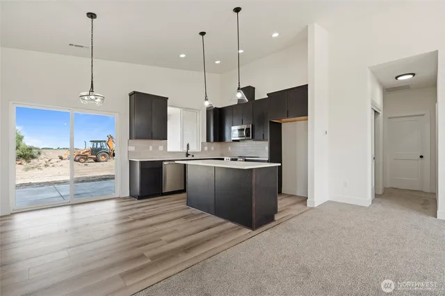 a large kitchen with kitchen island a sink stainless steel appliances and cabinets