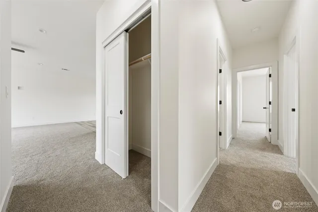 a view of a hallway with closet and wooden floor