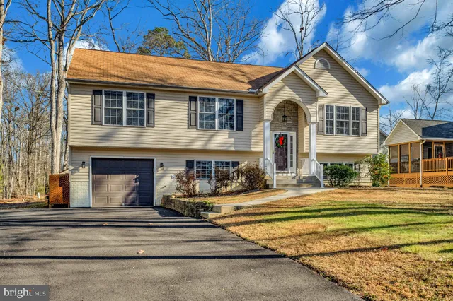 a view of a house with a yard and wooden fence