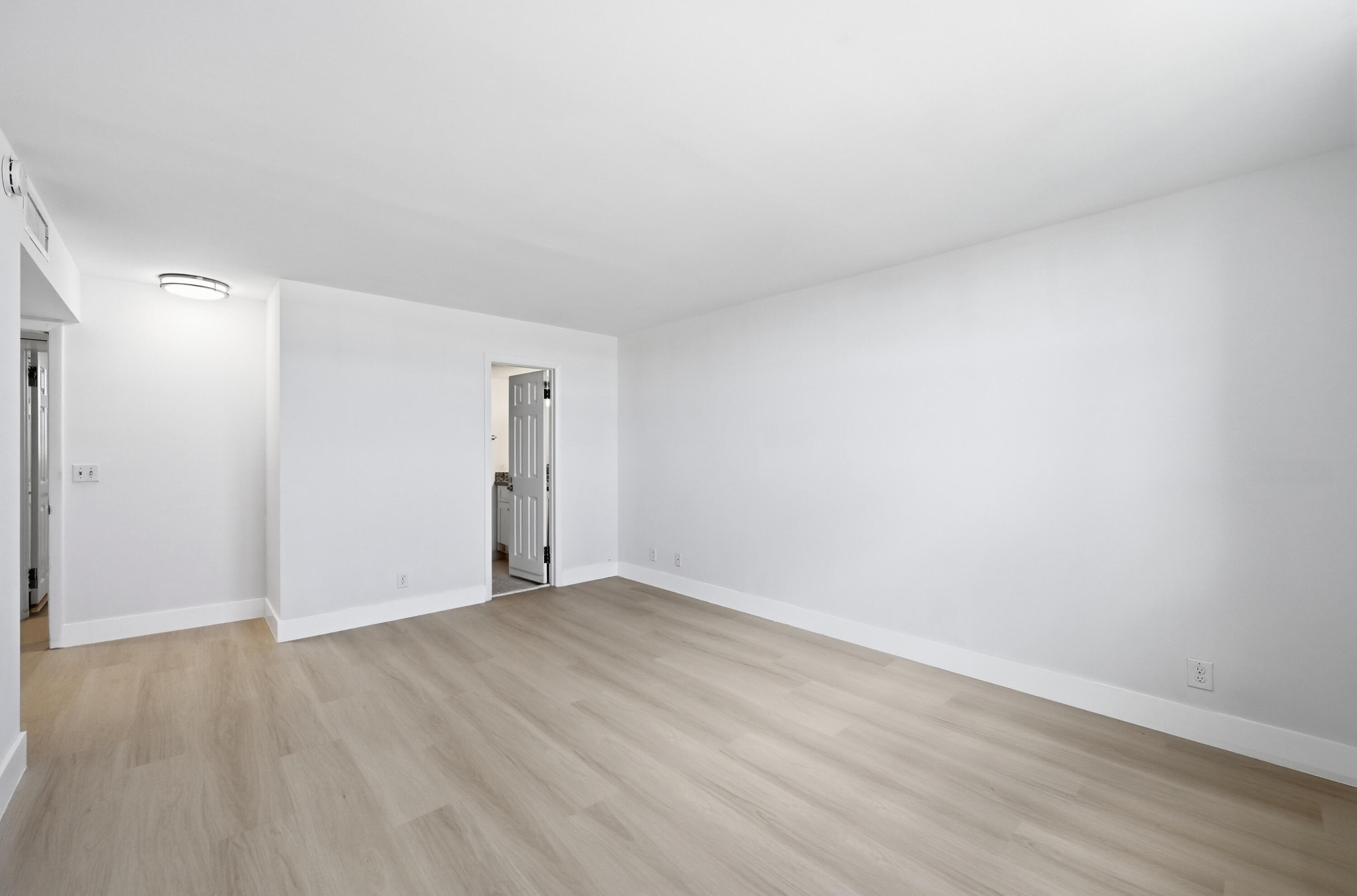 5700 Northwest 2nd Avenue, Unit 604 Boca Raton, FL 33487 - Photo 11 of 43 a view of an empty room with wooden floor and a window