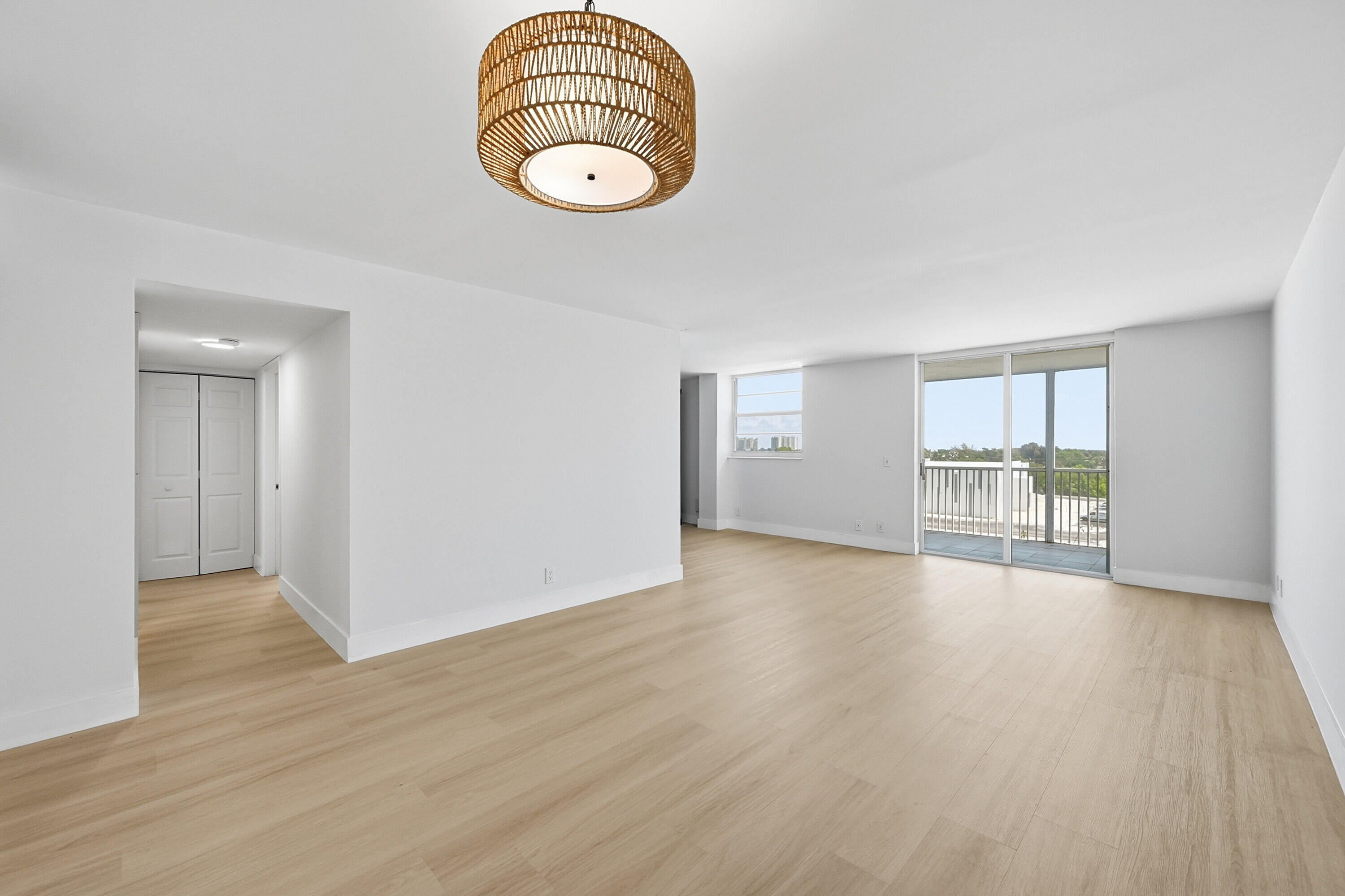 5700 Northwest 2nd Avenue, Unit 604 Boca Raton, FL 33487 - Photo 5 of 43 a view of an empty room with wooden floor and glass door