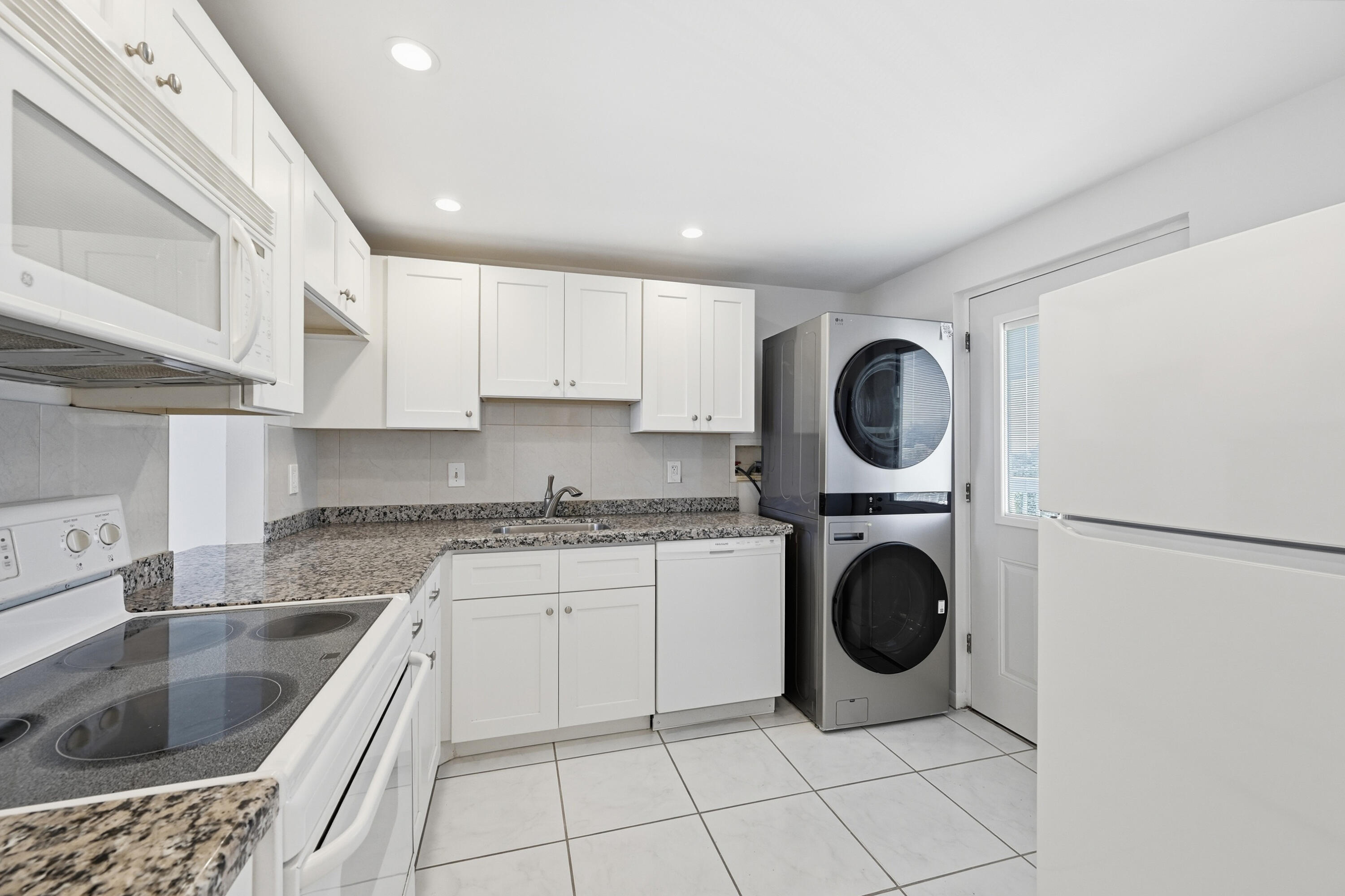 5700 Northwest 2nd Avenue, Unit 604 Boca Raton, FL 33487 - Photo 8 of 43 a kitchen with a sink a stove top oven and cabinets