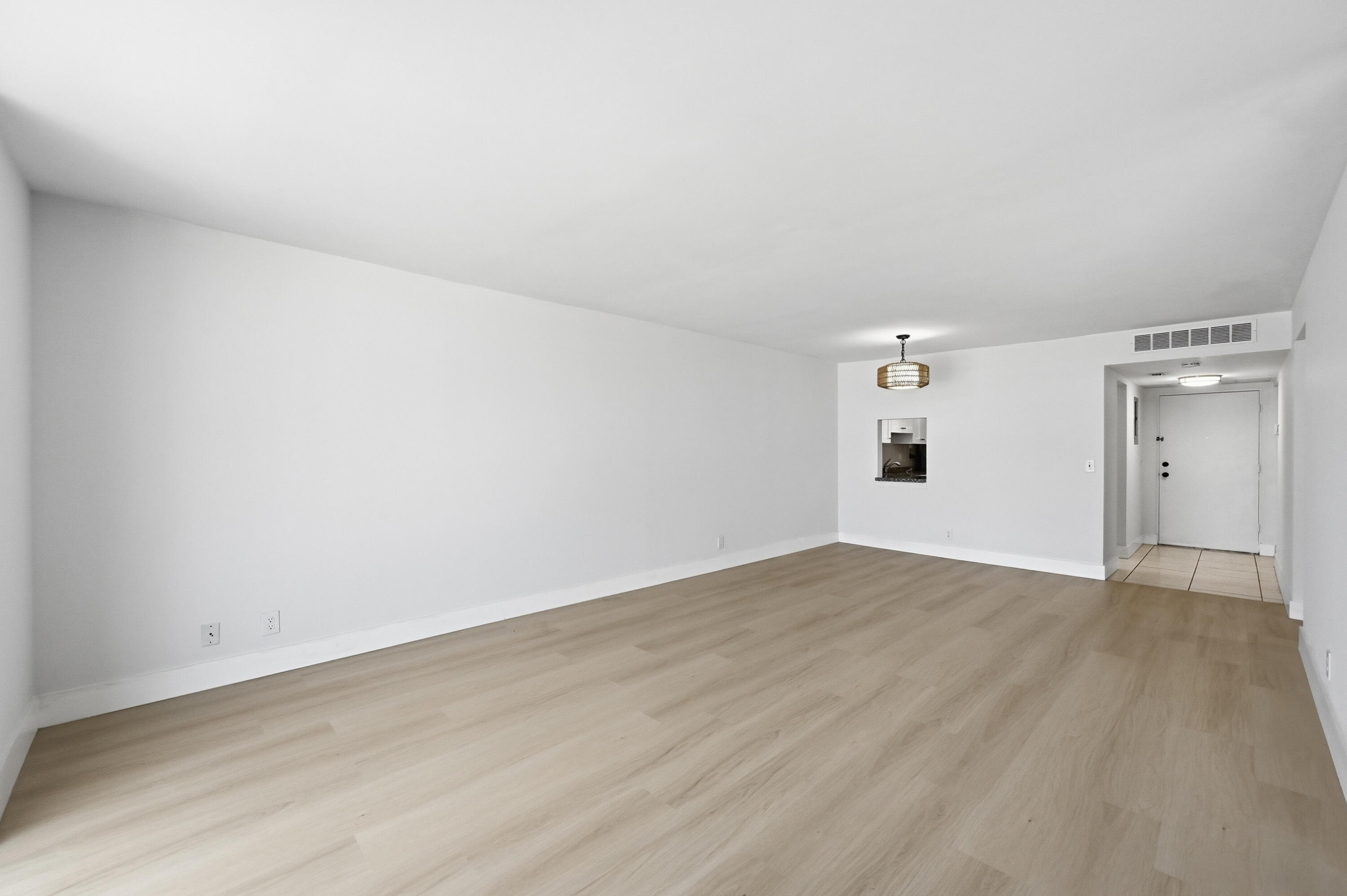 5700 Northwest 2nd Avenue, Unit 604 Boca Raton, FL 33487 - Photo 9 of 43 a view of an empty room with wooden floor and a window