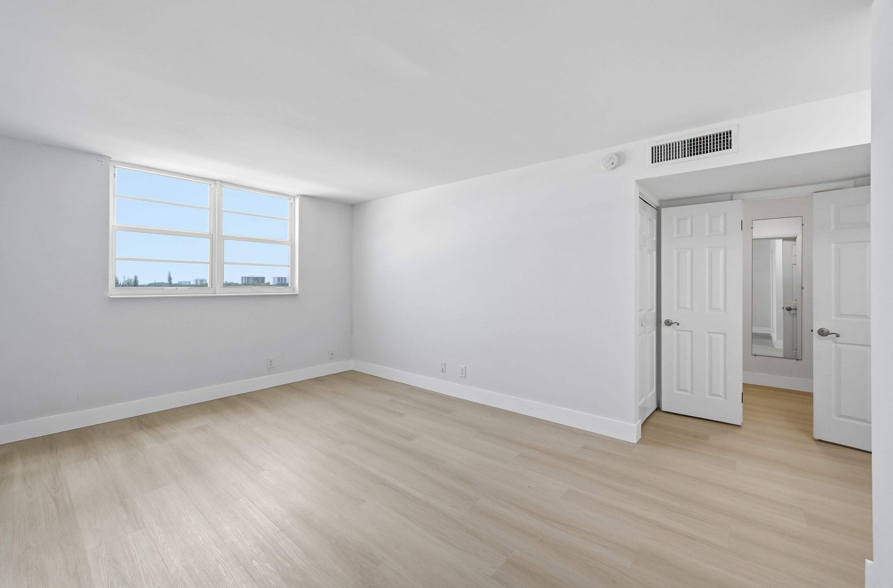 5700 Northwest 2nd Avenue, Unit 604 Boca Raton, FL 33487 - Photo 10 of 43 a view of an empty room with wooden floor and a window