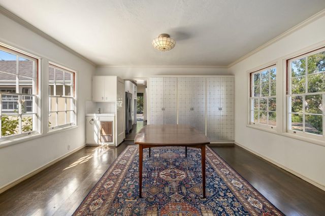 a view of a livingroom with wooden floor and a kitchen