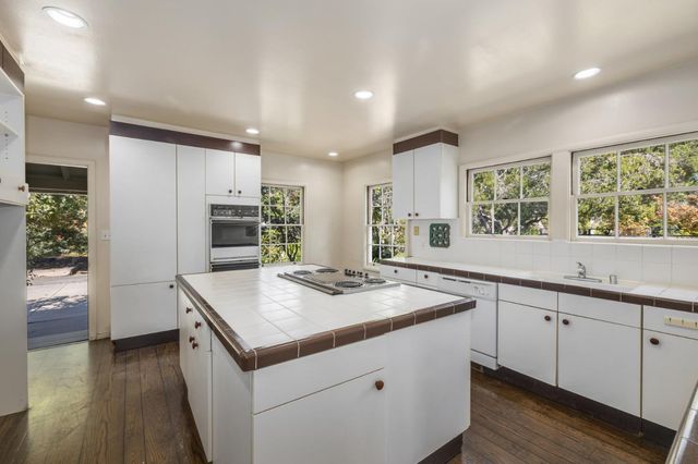 a spacious bedroom with a bed and a lamp on dresser