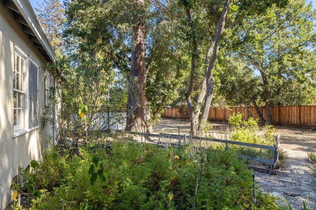 a vase of flowers sitting on a table in front of a glass door