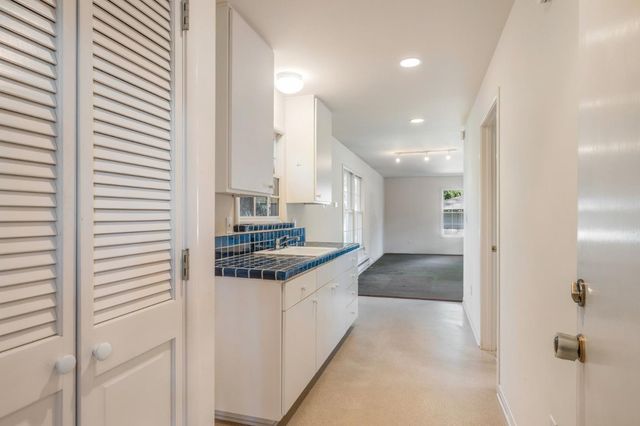 a view of a kitchen with wooden floor and electronic appliances